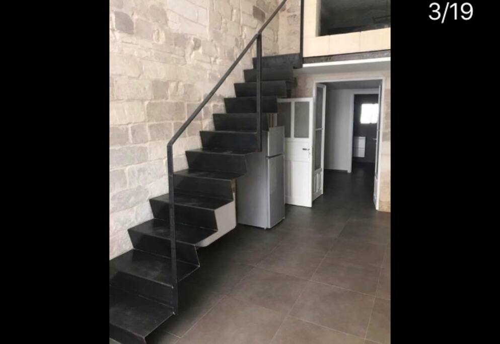Soggiorno e scala in ferro per accesso alla camera da letto