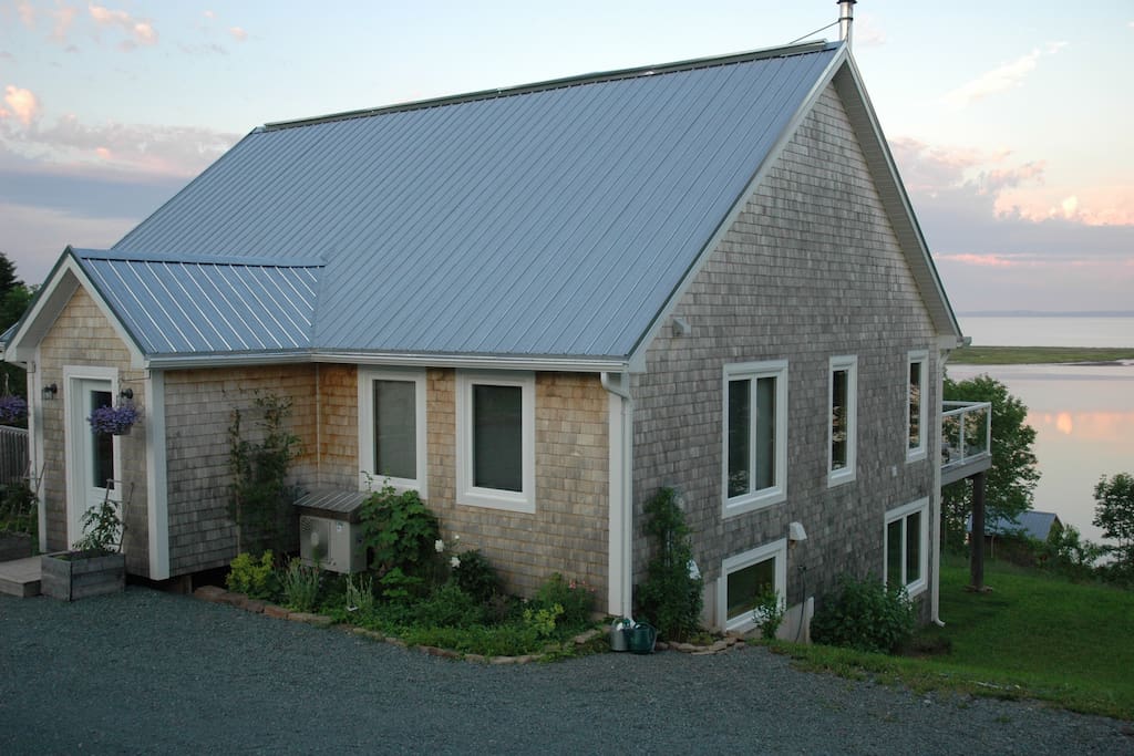the cedar-shingled home looks out onto St. Georges Bay, and is surrounded by gardens