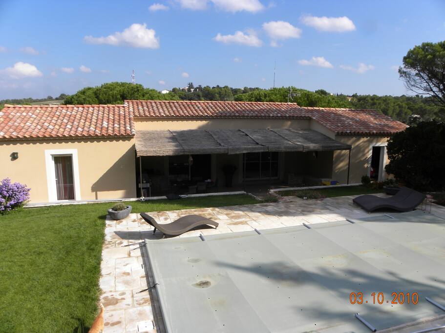 Vue sur la terrasse ombragée et la piscine
