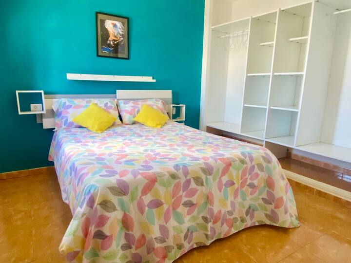 Habitación principal con armario abierto