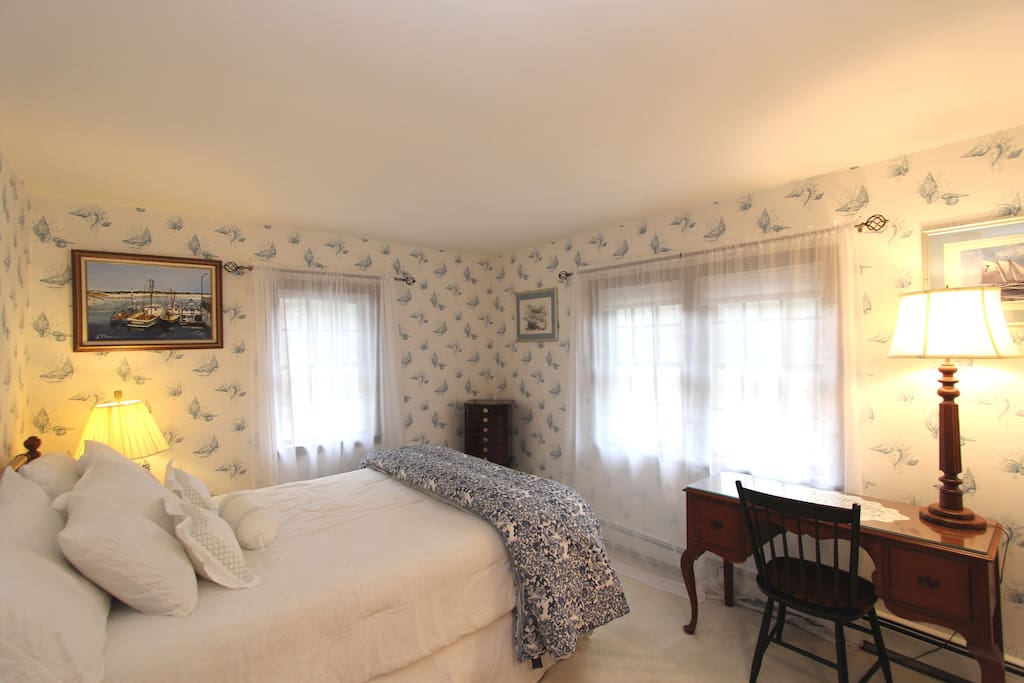 Queen Suite, with 1/2 bath, desk and 3 windows. This room is bright and sunny with shell wall paper. Everyone says this room is Capey and makes them feel, comfortable and homey.