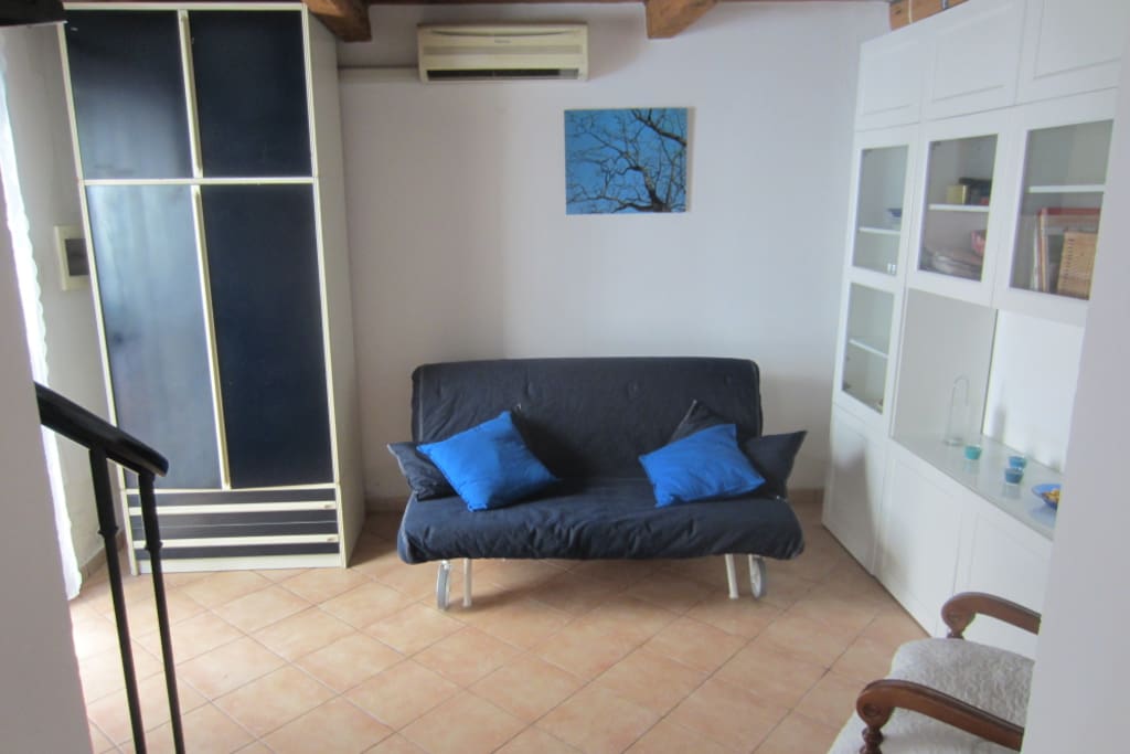 Sala con divano letto. Living room with sofa bed.