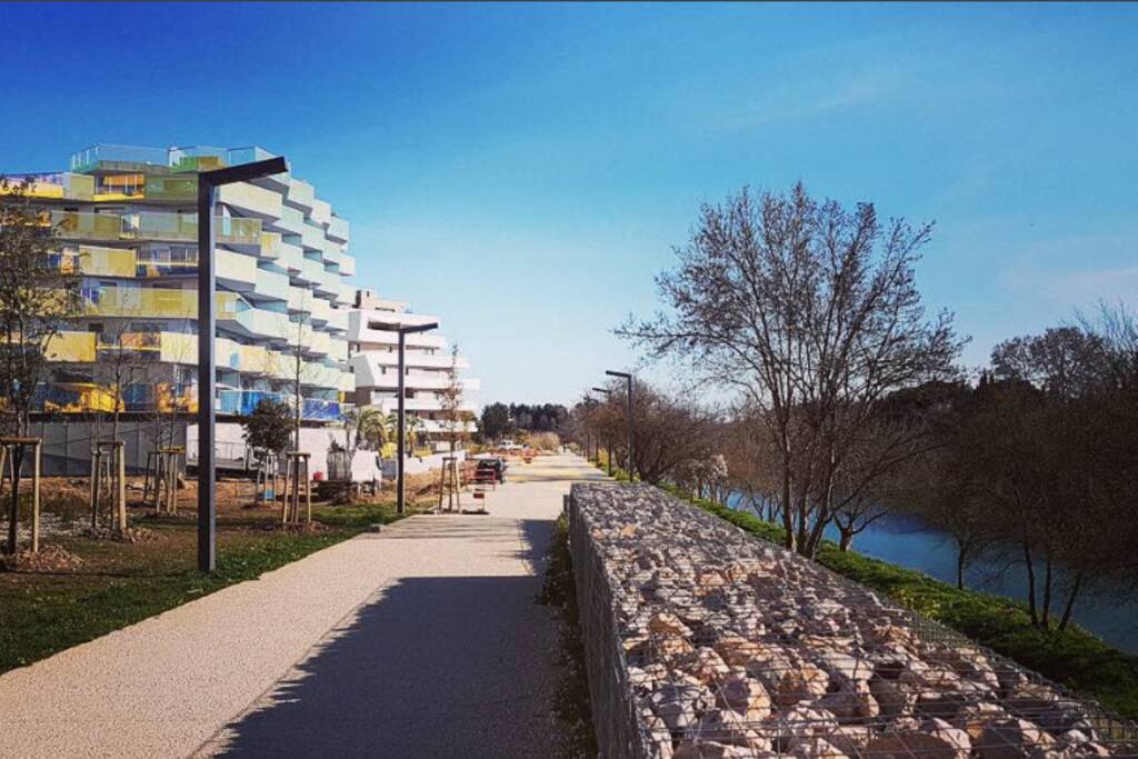 Dans le quartier le plus en vogue de Montpellier, « Port Marianne - Rive-Gauche », son écrin de calme et de verdure vous permet de bénéficier de toutes les commodités à proximité immédiate : tramways, commerces, restaurants, galerie d’art, centres commerciaux ou clinique. Les accès sont également des plus rapides aussi bien pour se rendre à la plage, au centre-ville, qu’à la gare, l’aéroport ou l’autoroute.
Résidence emblématique du quartier au même titre que diverses Résidences telles que l'Arbre Blanc, Le Nuage, Le Wellness, Art Code, Néo Lez ...