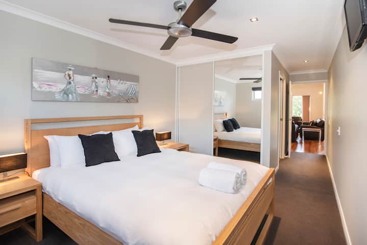 Საძინებელში არის დიდი ხის საწოლი Queen, ხრაშუნა თეთრი თეთრეულითა და შავი აქცენტის ბალიშებით. Საწოლთან დგას მაგიდები ლამპებით, ჭერის ვენტილატორით და სარკისებური სასრიალო გარდერობის კარებით. Ოთახი მყუდრო და კარგად განათებულია.