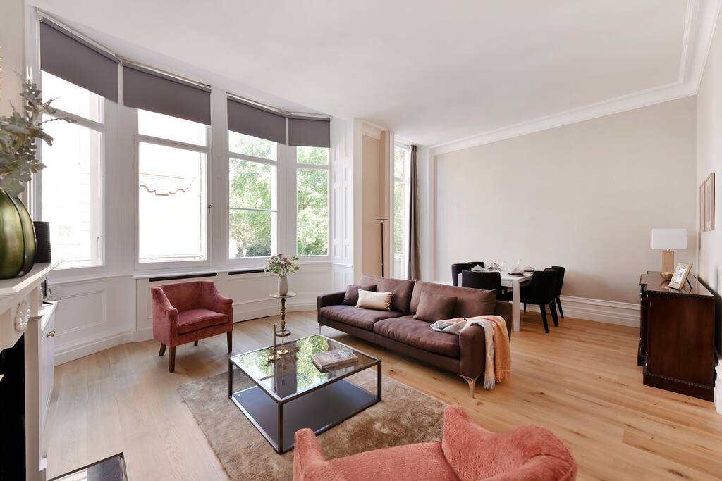 The spacious, elegant living room with high ceilings, garden view, fireplace, TV, Free WiFi and more