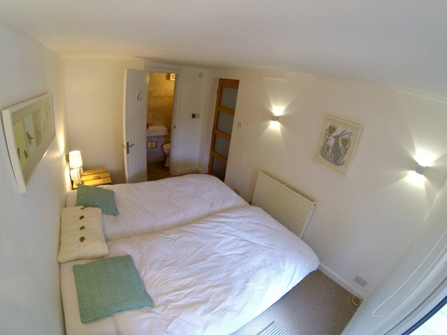 En-suit room with twin beds and large shower - double doors which open out in garden.