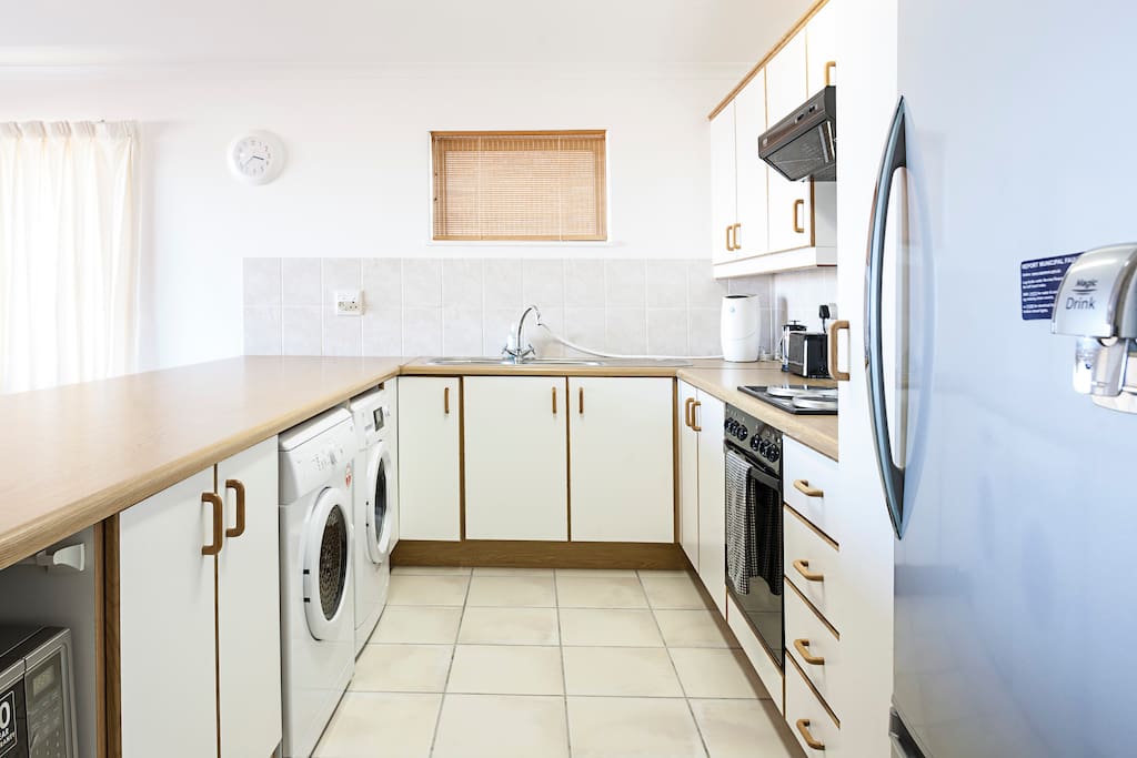 Open plan kitchen, with washing machine & dryer.