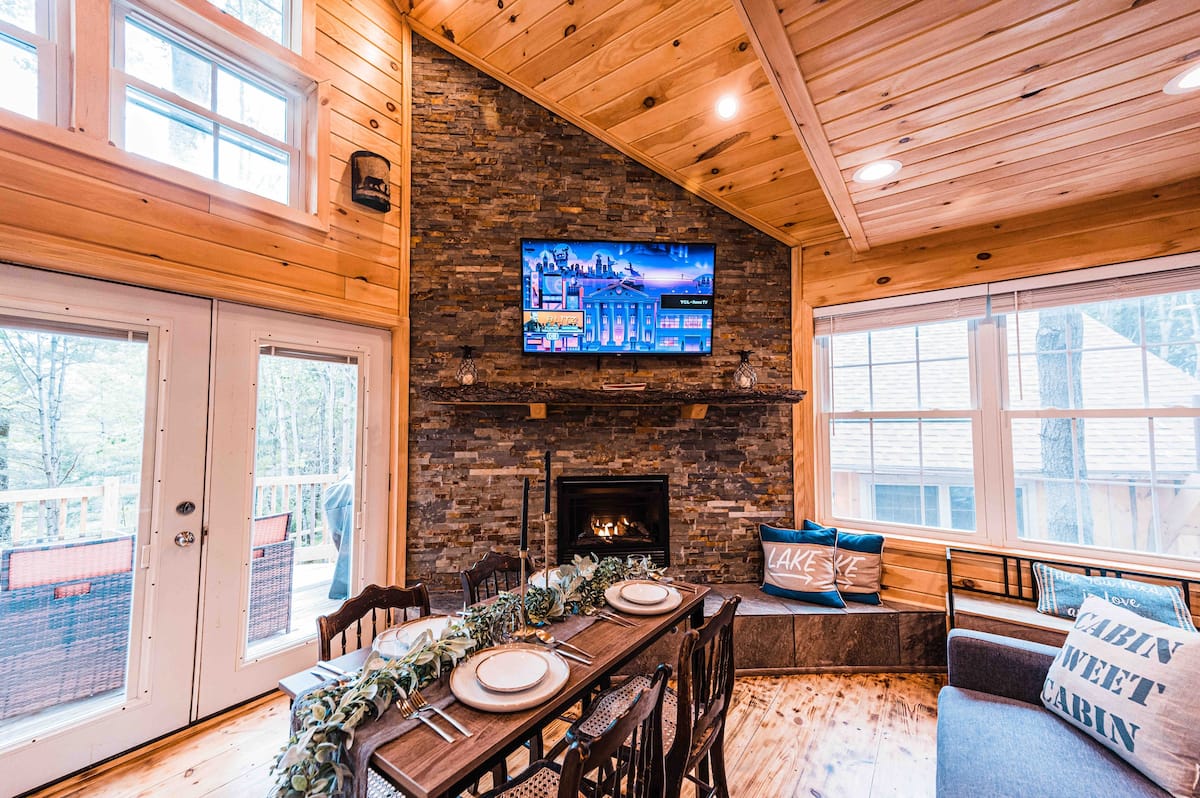 An elevated treehouse in Maine with elegant design features and beautiful stone hearth