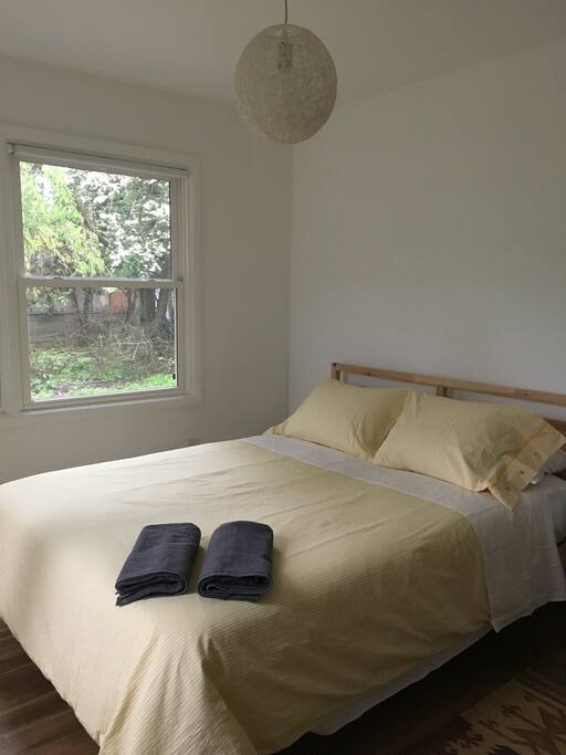 The room has a comfy queen bed with a variety of pillows and extra blankets