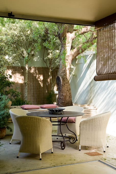 Beautiful kitchen nook, with glass doors on both sides, opening for a sheltered 'al fresco' experience.