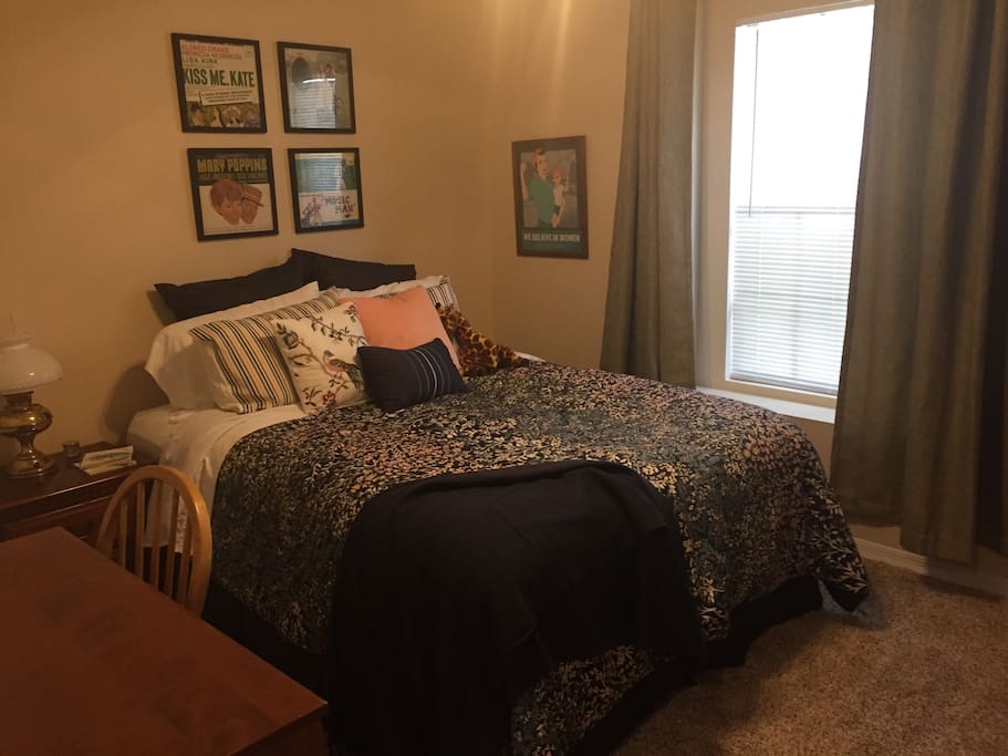Guest room with queen bed, desk and printer, side table, dresser and mirror