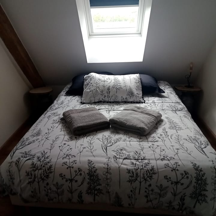 Chambre de l'étage avec un lit de 140x190, cette chambre possède également un lit bébé.