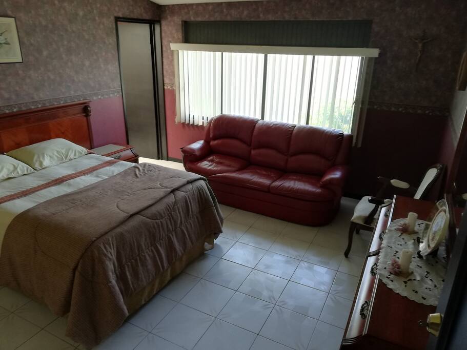 Habitación con cama matrimonial y sofá cama