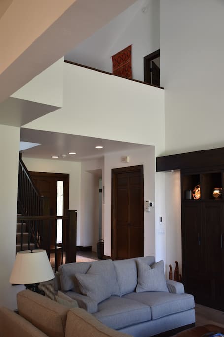 Looking from living room at front door and upstairs loft