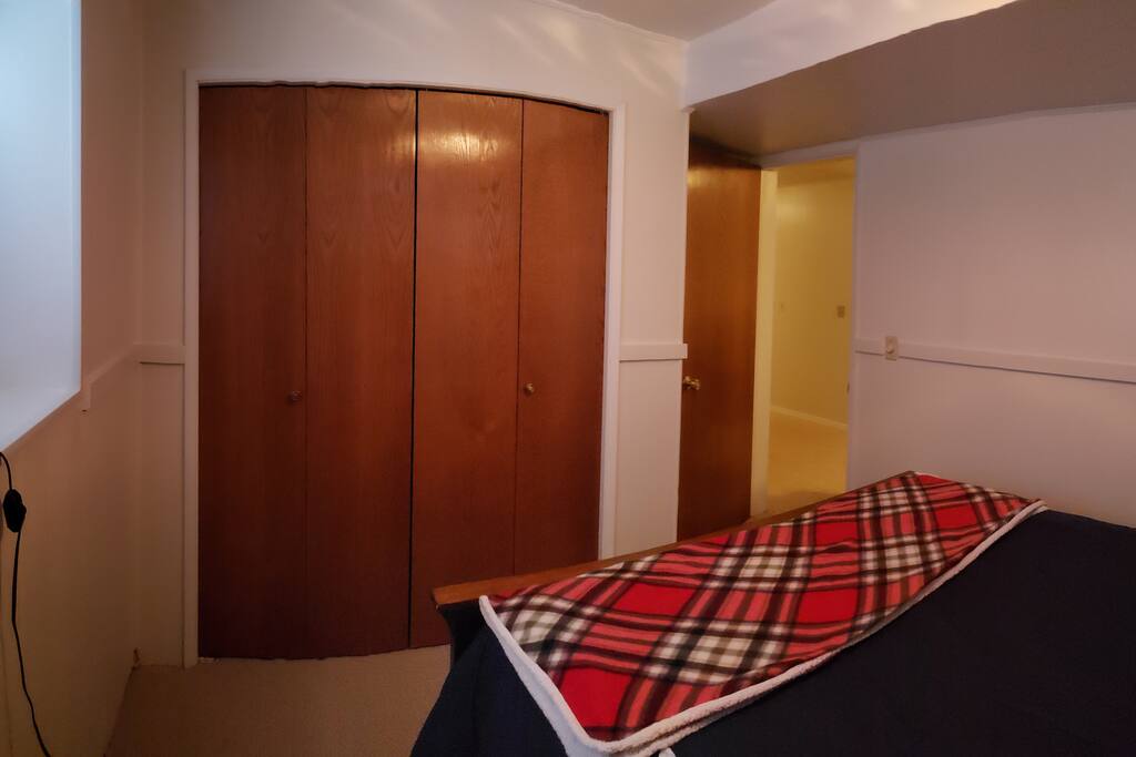 Bedroom entry and exit with roomy closet and hangers with luggage rack for your convenience.