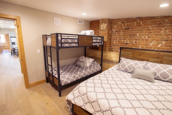 Druhá spálňa s manželskou posteľou Queen a poschodovými posteľami.  Druhá kúpeľňa s toaletou priamo pred týmito dverami.  V miestnosti je tiež skriňa, do ktorej si môžete dať oblečenie. 