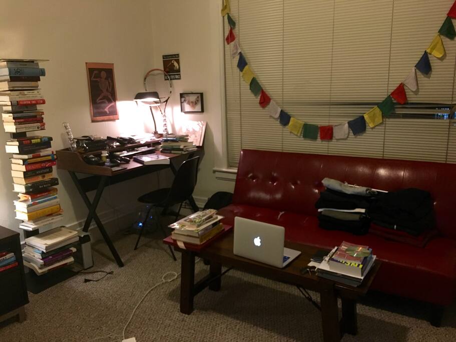 Red futon back folds down to lie flat. Desk for work.