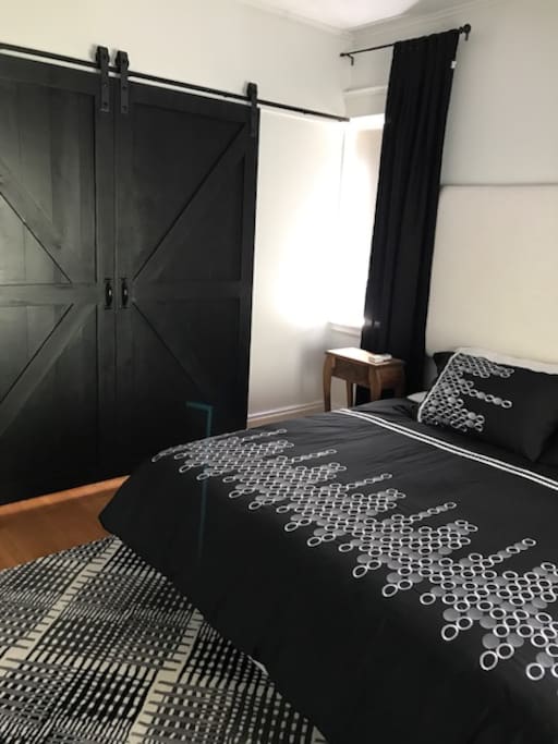 King bedroom with television, white and black decor