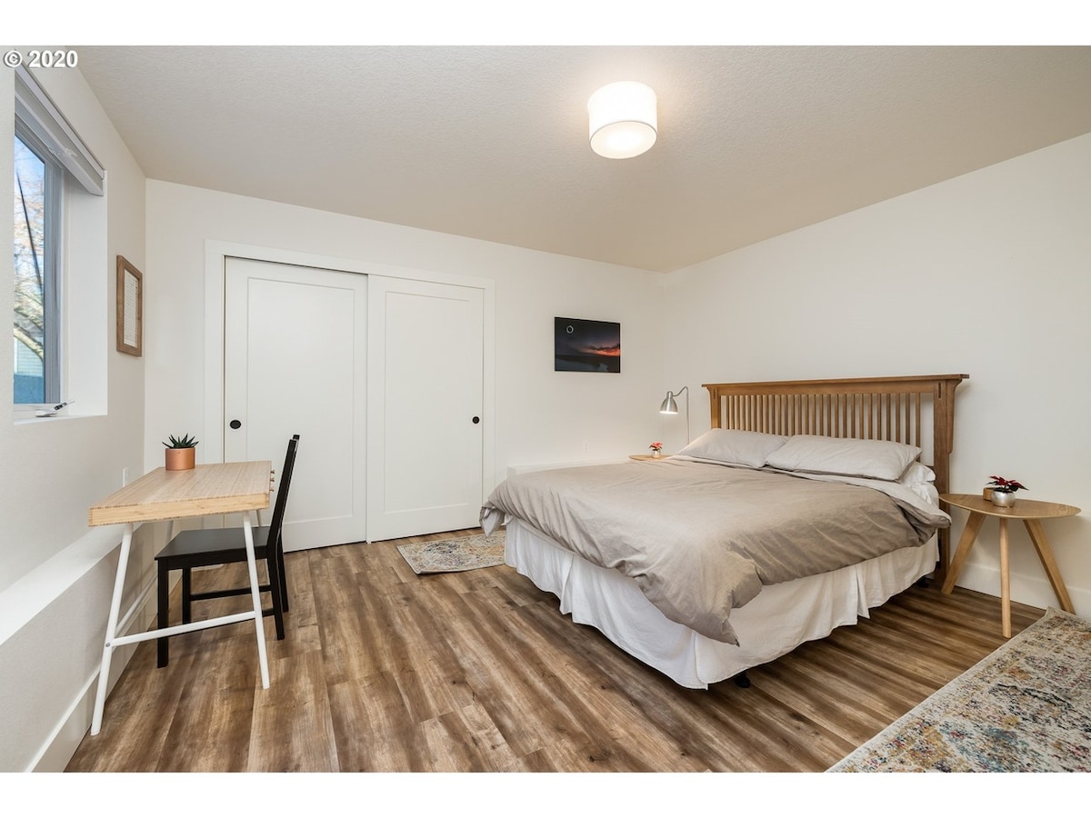 חדר שינה עם מיטת קווין סייז, שולחן עבודה ושפע של ארונות