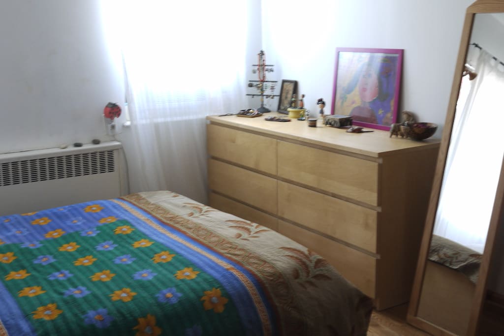 private main bedroom with queen size bed, arm chair and closet space