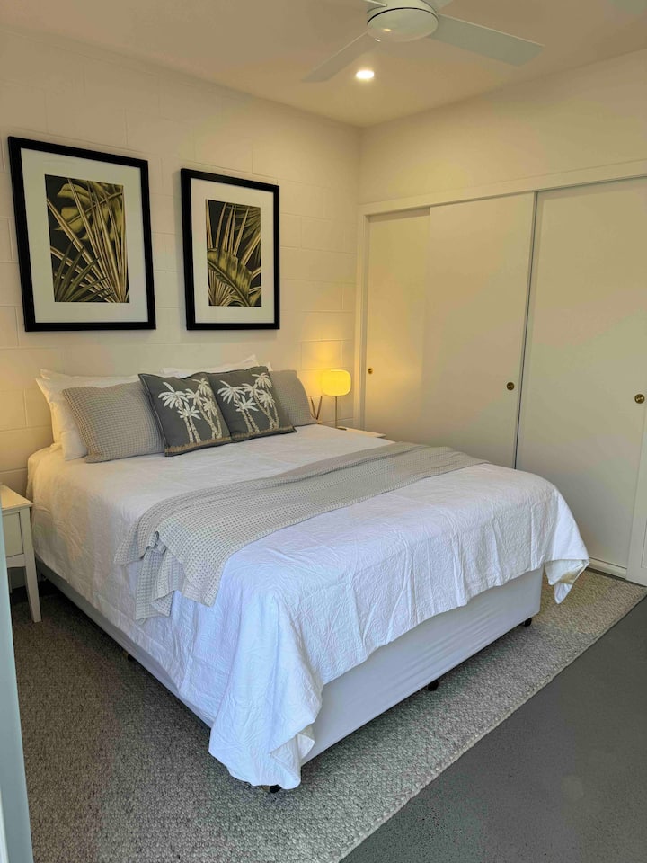 חדר שינה שלישי עם QB בקומה 1 עם סוויטה וגישה לאזור גינה עם שולחן וכיסאות בחוץ. 