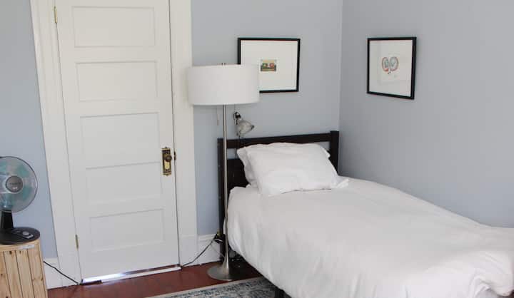 Bright bedroom corner w/ crisp bedding & clean-lined decor.