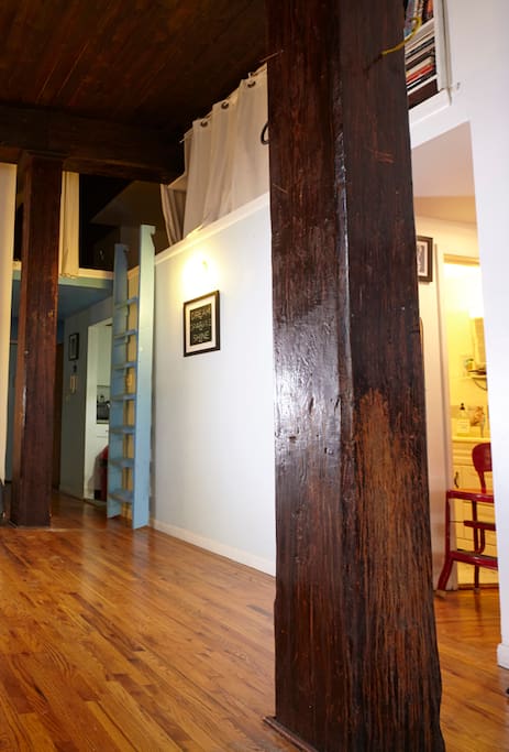 View from living room to kitchen and front door, bathroom and bedroom to right