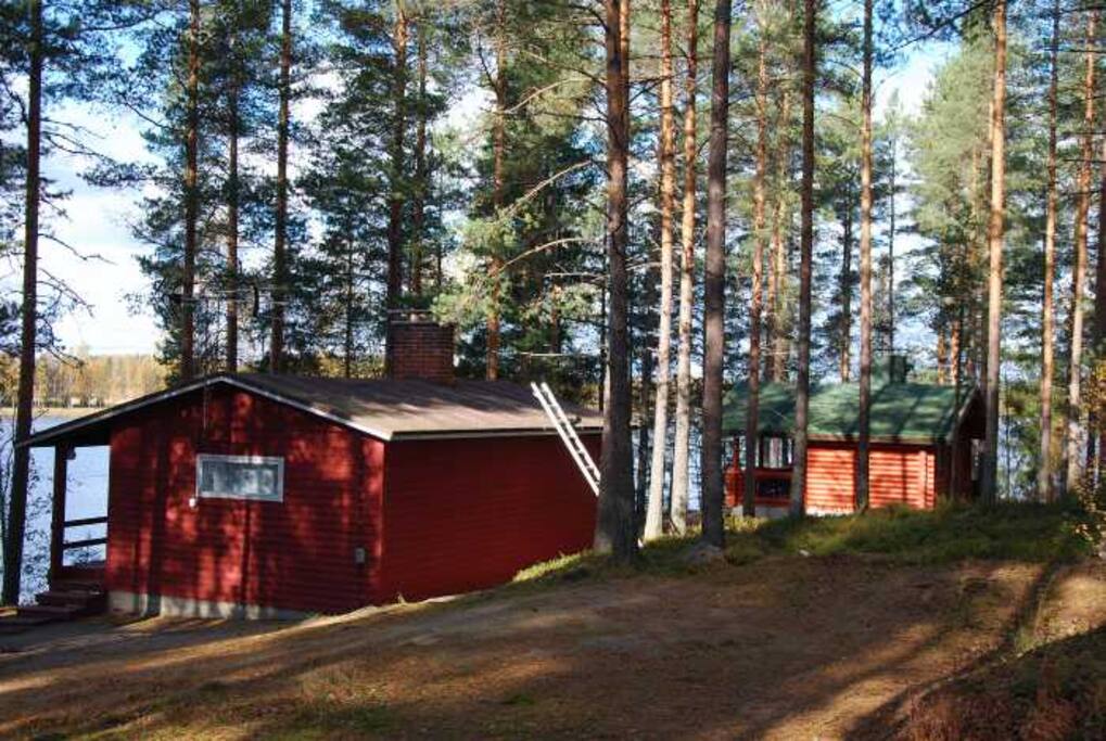 Näkymä parkkipaikalta, päärakennus ja saunamökki
