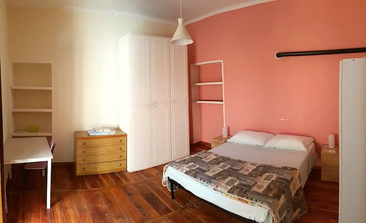 Room with double bed, wardrobes, table and balcony.
Camera da letto con letto matrimoniale, scrivania, armadi e balcone.