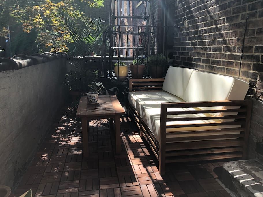 Recently refurbished patio with a loveseat and another bench. It's a beautiful place to enjoy your morning coffee or just relish being at home outside in Brooklyn Heights!