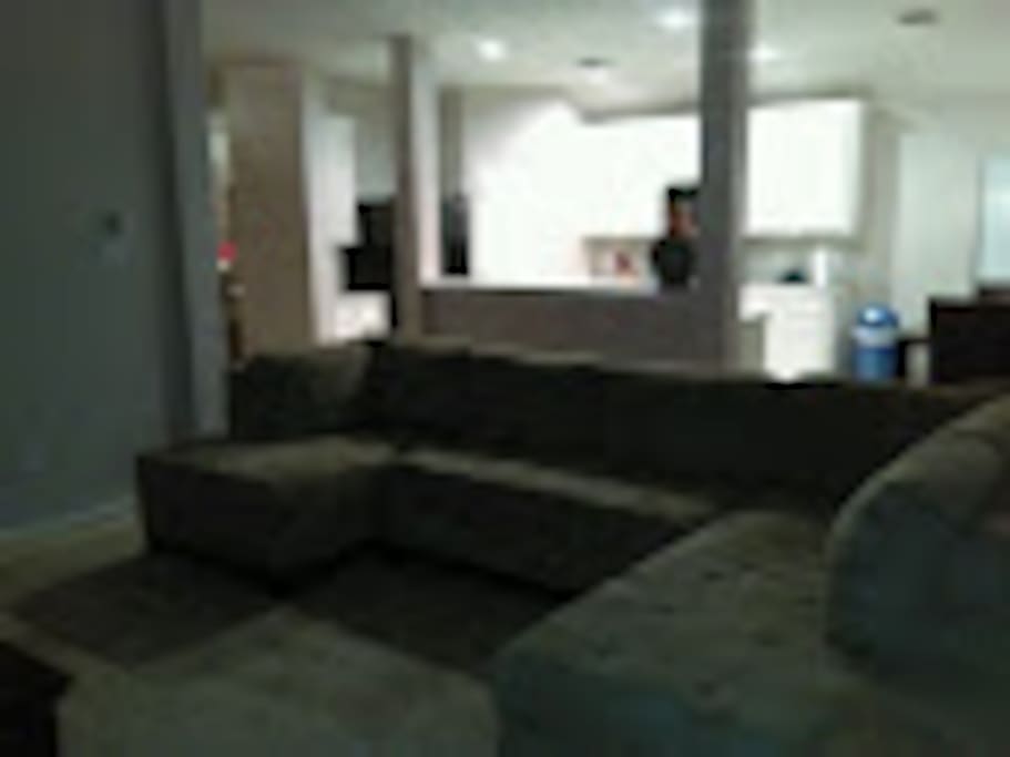 Front view of sofa with open kitchen in background for television viewing from afar.