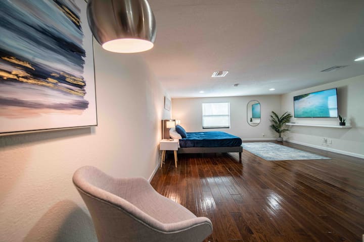 Hlavná spálňa s manželskou posteľou King, 65-palcovou televíziou Roku, kreslom na sedenie v dosahu (DWR) a hlavnou skriňou.