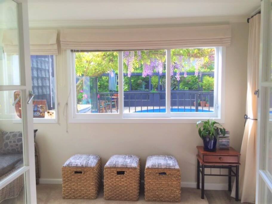 The sunroom, looking from the bedroom French doors, out to the pool area and back garden.