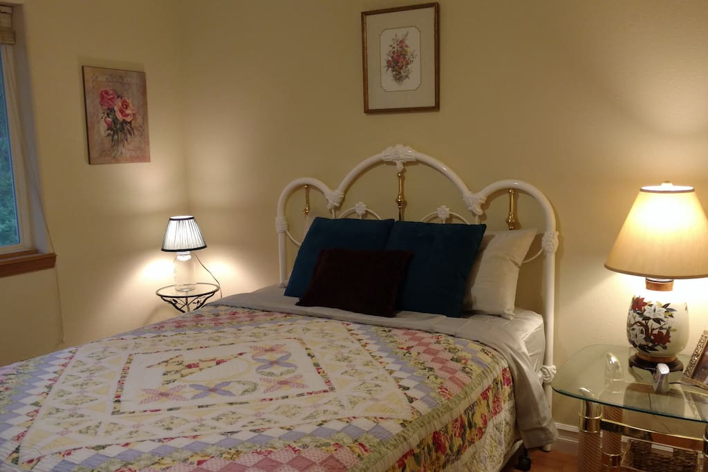 Rose Room queen size bed with full closet, private bathroom next door, view of the forest