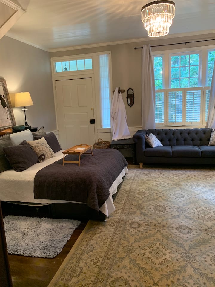 Pogled na spavaću sobu s velikim bračnim krevetom u prizemlju s kaučem u prvom planu