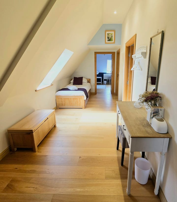 Open plan sleeping area on the first floor with one single bed and one 'Put-you- up' single bed-chair 