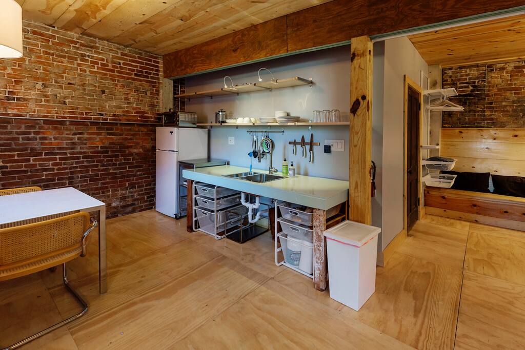 Kitchenette features a mini fridge, single burner induction cooktop, electric hot water kettle, toaster/convection oven, a burr coffee grinder and French press coffee maker.