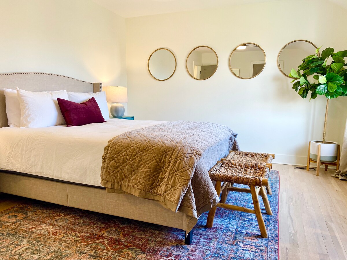 Este gran dormitorio luminoso tiene un televisor inteligente de 40pulgadas, cama tamaño queen de diseño, un armario grande con perchas y portaequipajes, así como cortinas opacas. 