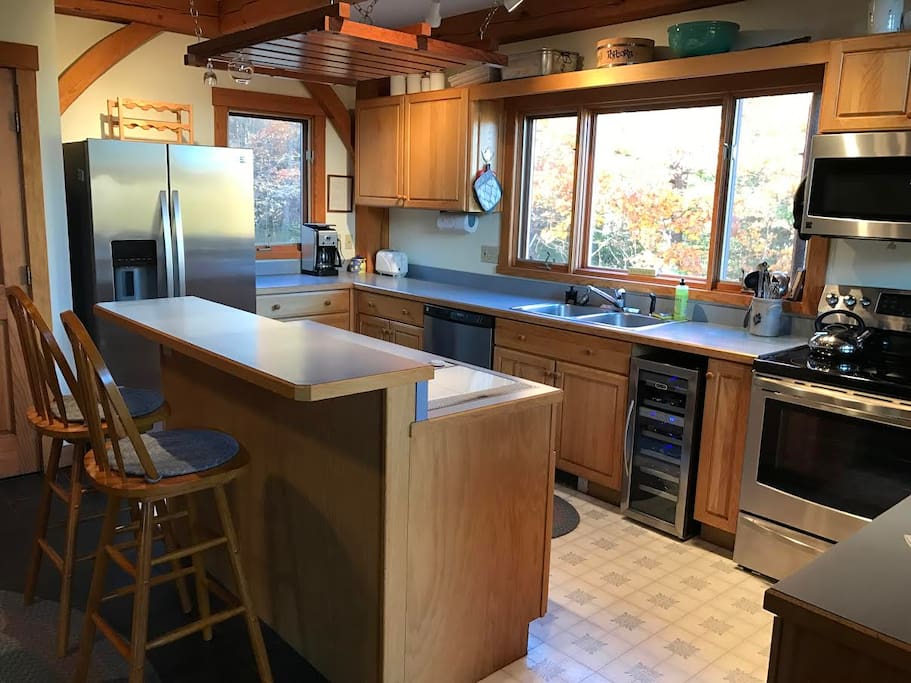 Inviting kitchen with prep island, seating and wine refrigerator