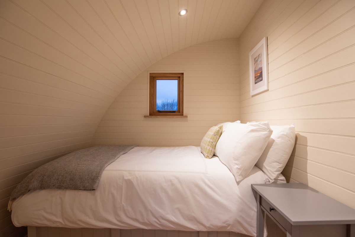 提供带埃及棉质床上用品、毛巾和浴袍的双人床