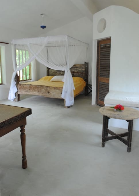 Spacious bedroom with King size double bed, comfortable mattress, cotton sheets and mosquito netting on windows and bed