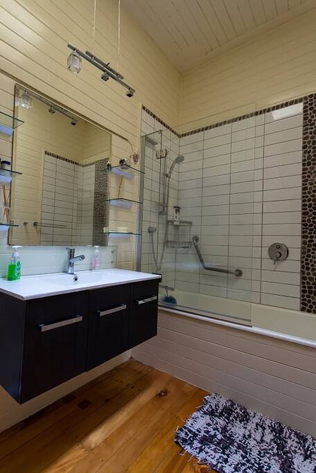 Spacious modern bathroom with bathtub, shower and toilet. There is also a second shower and toilet that can be used- not captured in photo
