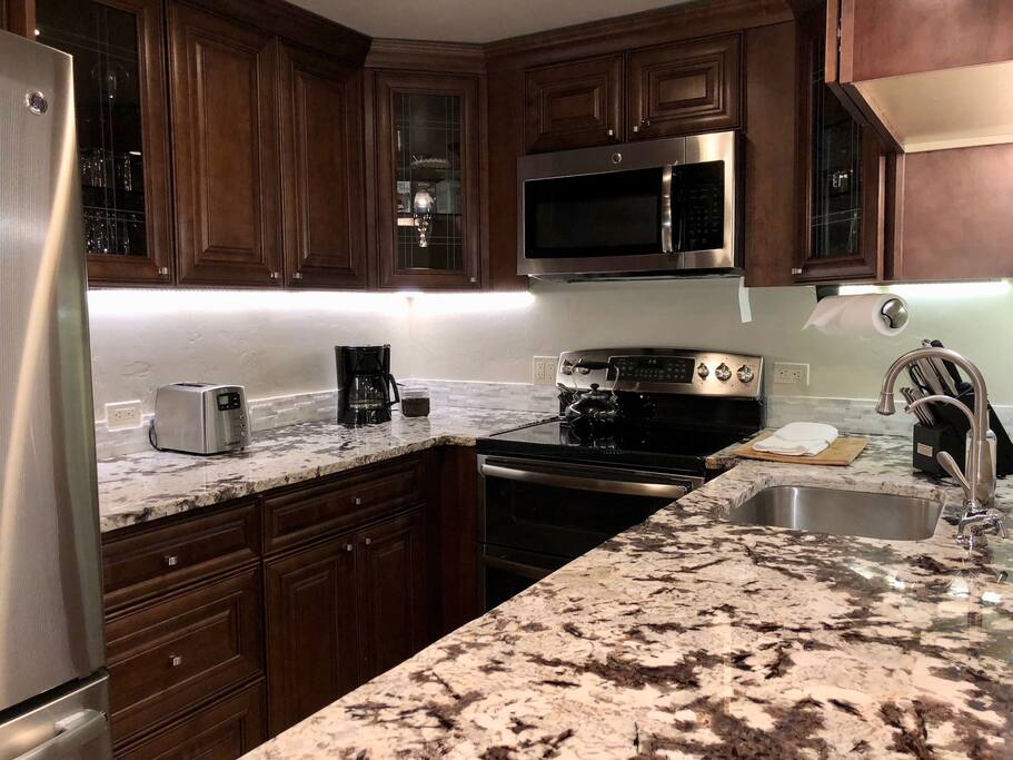 Gourmet kitchen with high end granite and stainless appliances: full size french door fridge with filtered wate, double oven, microwave, dishwasher, coffee maker
