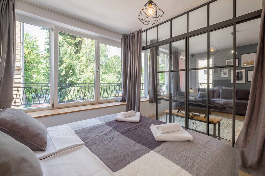Bedroom with living room behind the window wall