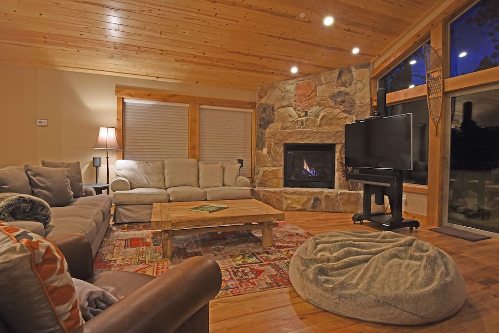 Living room, with fireplace, flat screen TV, and access to the deck