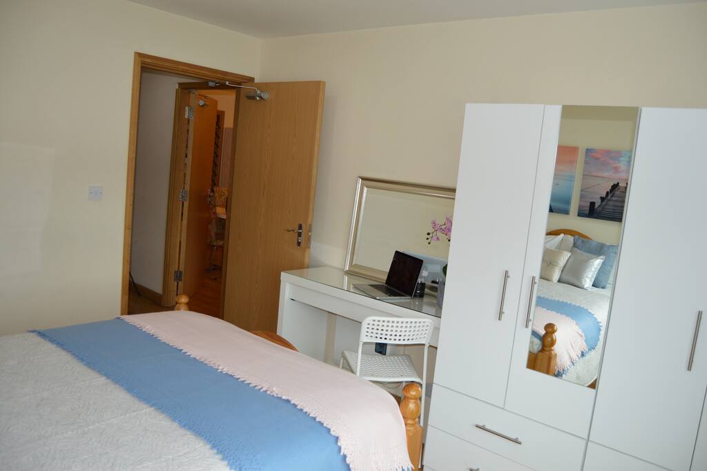 Main double bedroom with desk, wardrobes and hangers, blackout blinds