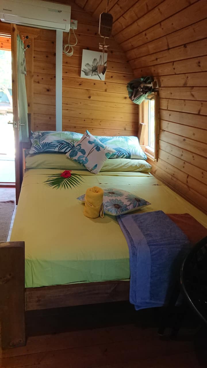 חדר שינה בבקתה עם עיצוב טרופי. 