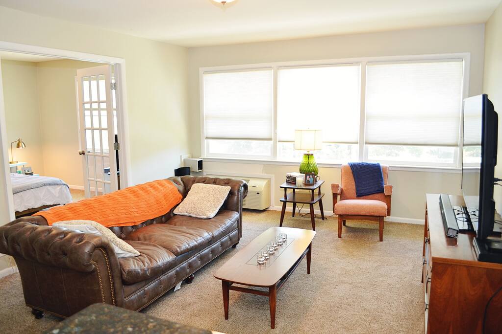 Bright and airy living room equipped with a 55" LED TV and Bluetooth enabled soundbar.