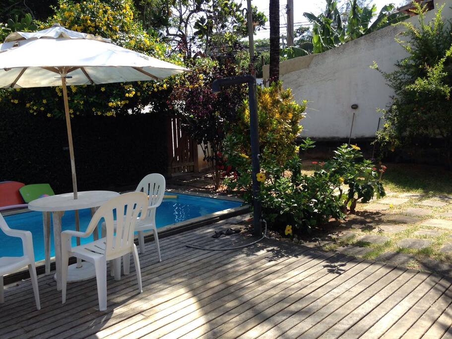 Deck com mesa, cadeiras de piscina e churrasqueira portátil