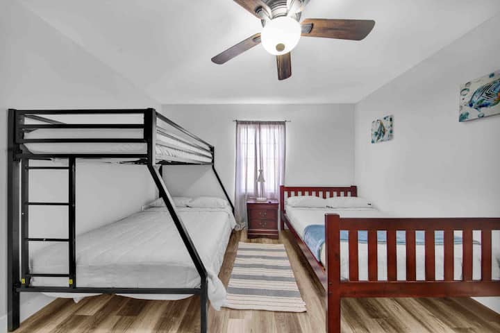 Chumba cha pili cha kulala kilicho na kitanda cha malkia na kitanda cha ghorofa kilicho na kitanda cha malkia na pacha ambacho kinalala hadi wageni 5. 